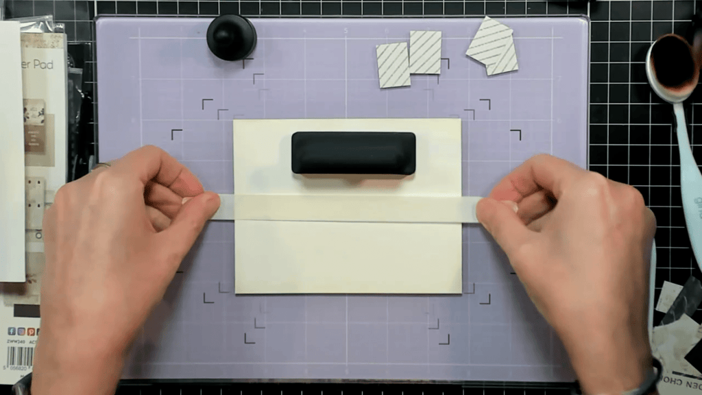 photo showing how i used My Magnetic Glass Mat and a MegaPawn Magnet to hold the card base down when applying the Low Tack Tape
