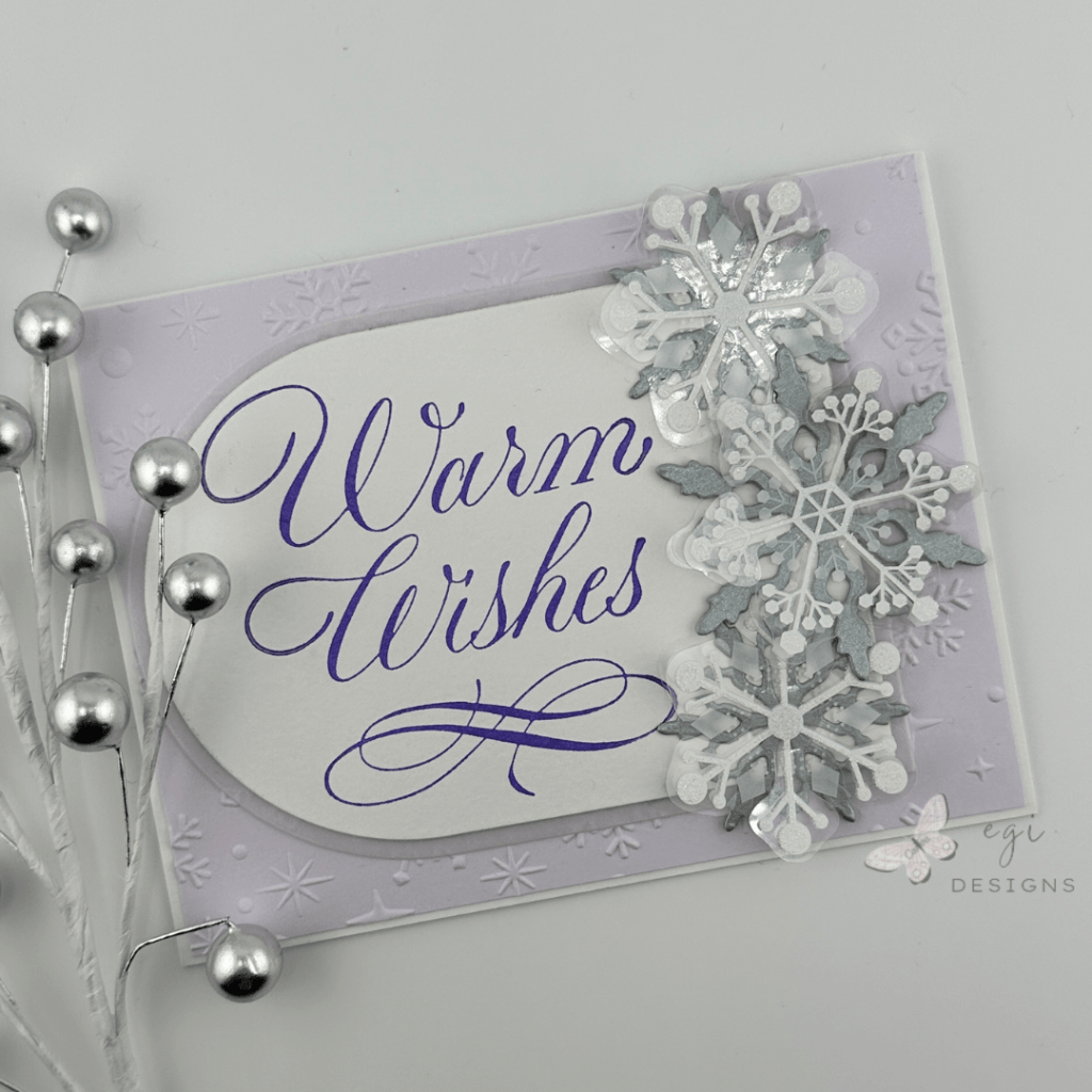 photo of card using Spellbinders Dimensional Snowflakes, Copperplate Warm Wishes, Sparkling Snow Embossing Folder, Layering Snowflakes Die Set, and Essential Arched Die Set.
