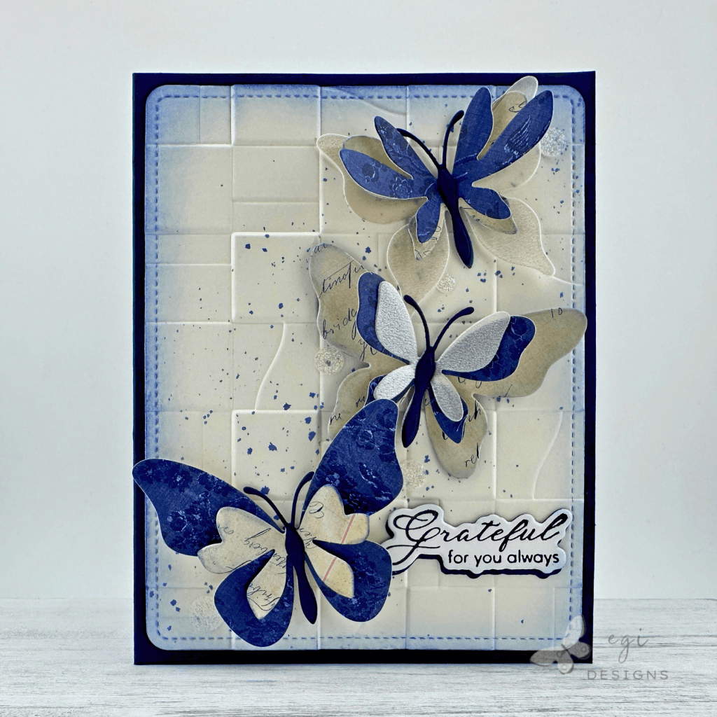 photo of card using altenew fluttering fantasies die set, tim holtz palette: indigo paper, altenew paper rhythm embossing folder